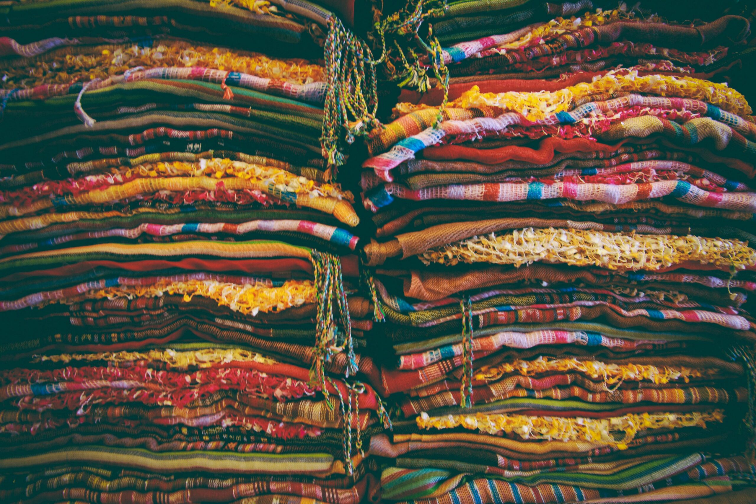A brightly colored poncho folded neatly into a small pouch