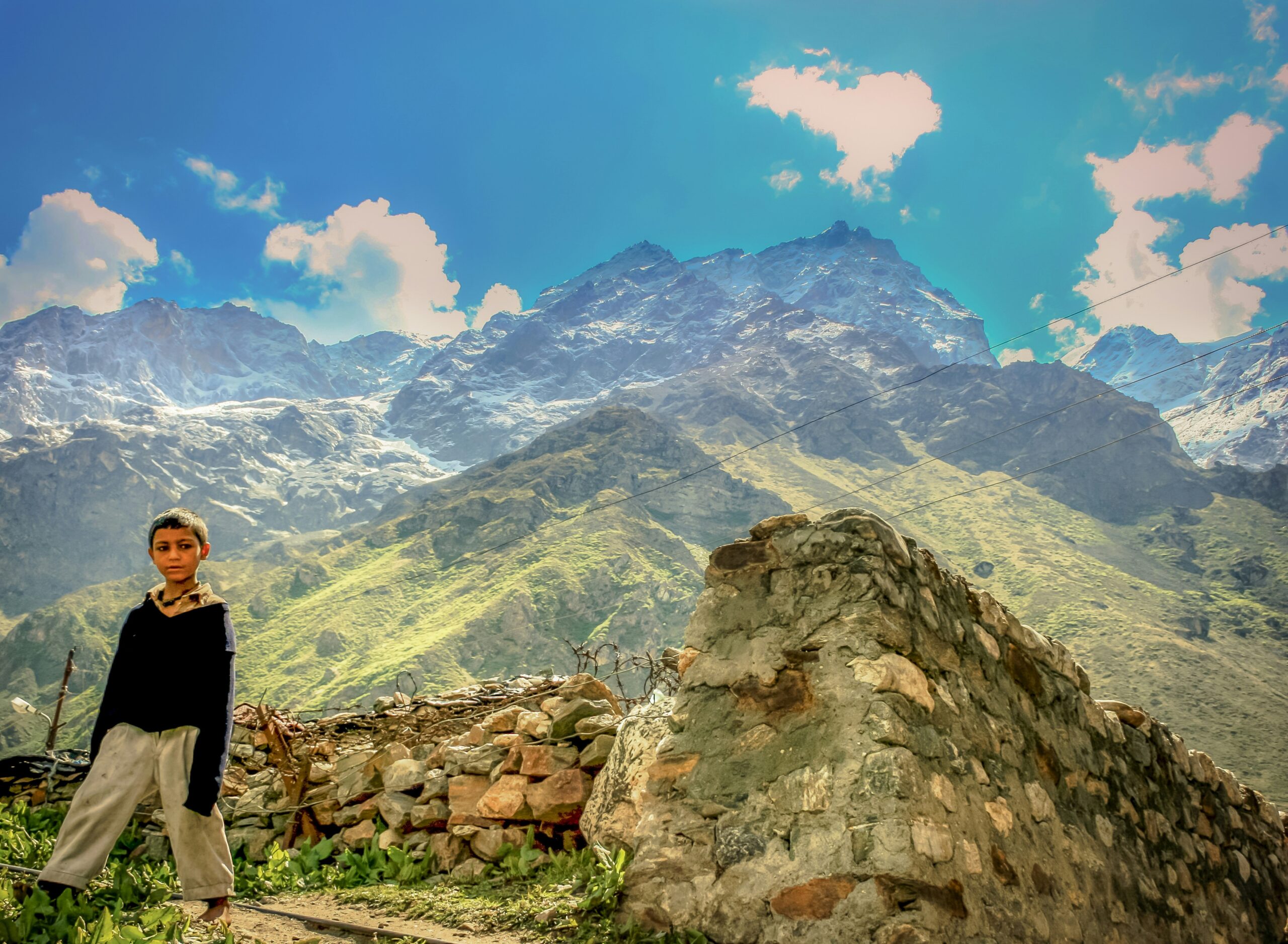 A smiling traveler posing with a ventilated poncho amidst scenic landscape