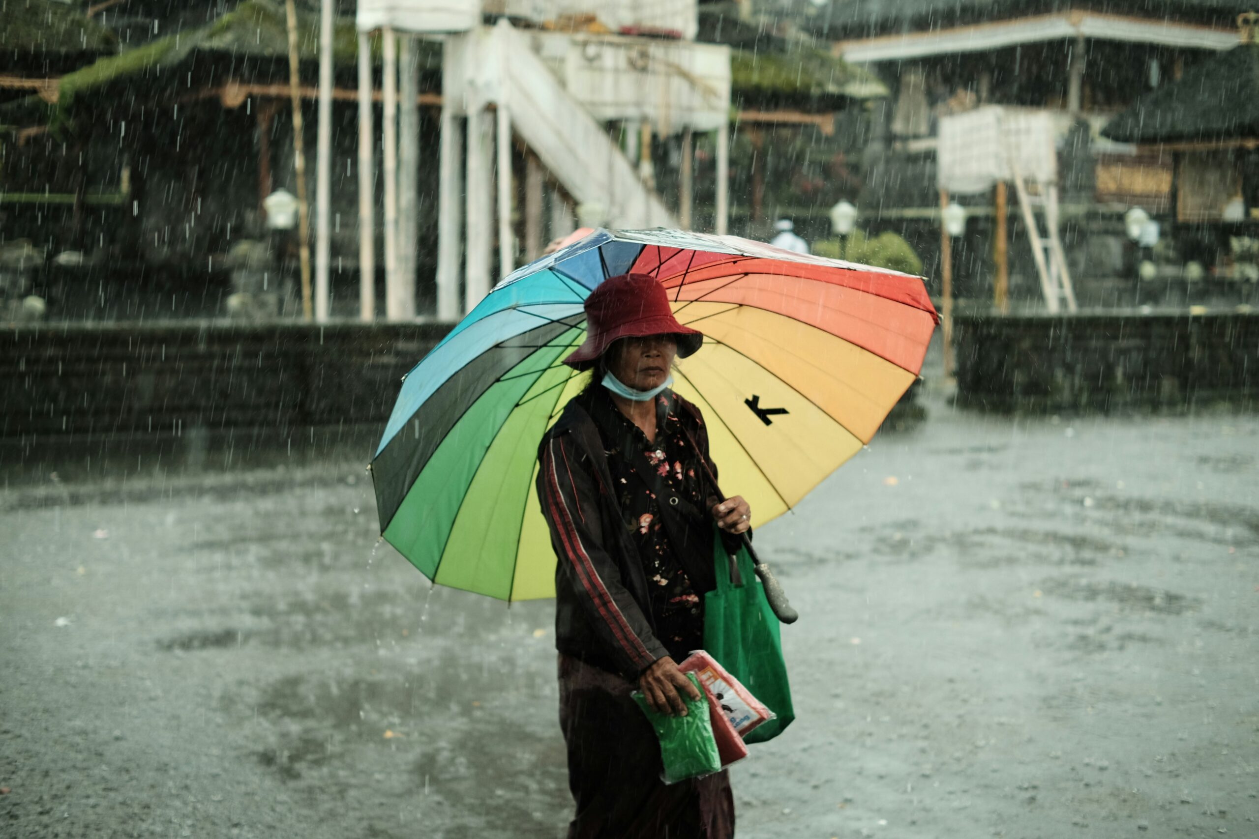 A traveler struggling with a non-ventilated plastic poncho in heavy rain