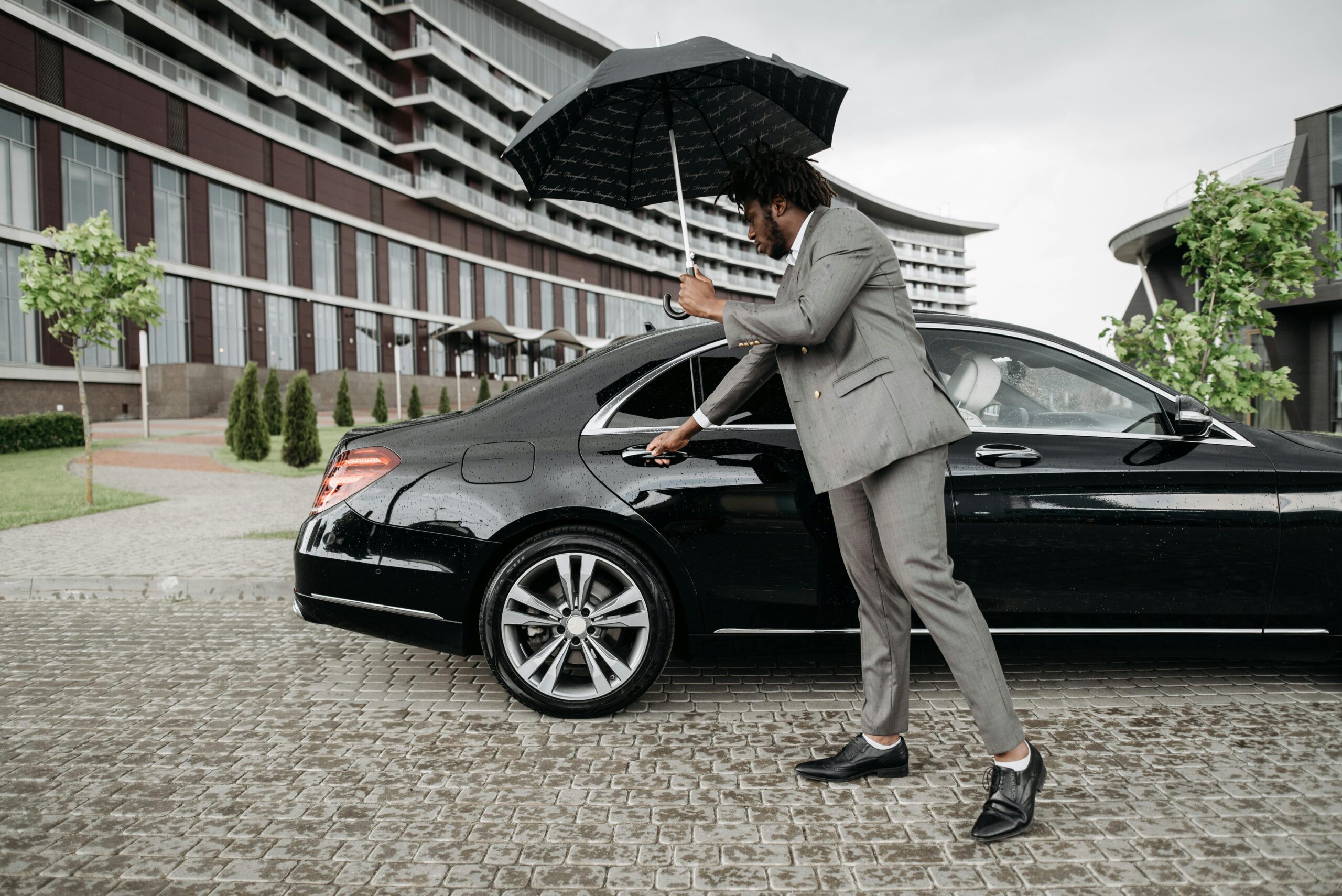 Traveler standing in the rain holding a broken umbrella